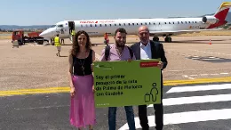 Foto del primer pasajero de la ruta Palma de Mallorca - Crdoba posando con un cartel que lo indica.