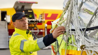 Un operario de DHL Express prepara los paquetes para su introdccin en un avin en un aeropuerto.