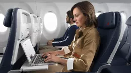 Pasajera de un avin de Air France utilizando un ordenador porttil con la conexin Wi-Fi gratuita de alta velocidad que ofrece la compaa con Starlink.