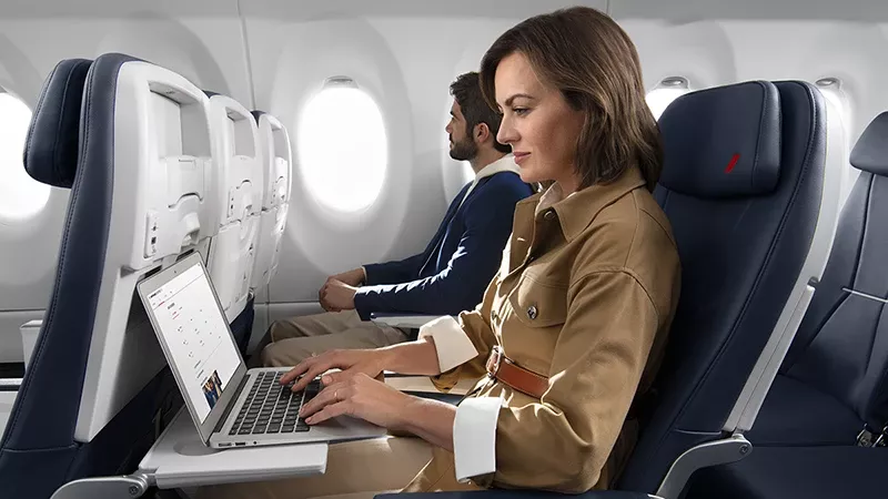 Pasajera de un avin de Air France utilizando un ordenador porttil con la conexin Wi-Fi gratuita de alta velocidad que ofrece la compaa con Starlink.