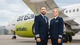 Pilotos de airBaltic junto a una aeronave de la compaa.