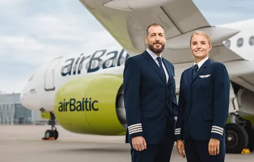 Pilotos de airBaltic junto a una aeronave de la compaa.